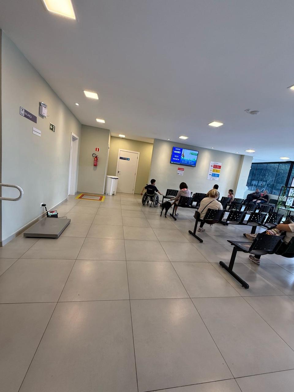 Sala de espera do Hospital Veterinário Municipal de Curitiba com tutores e seus animais aguardando atendimento